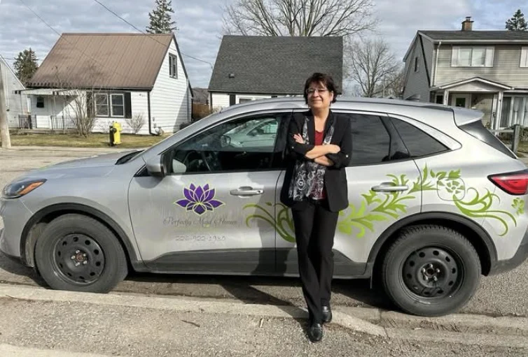 Valerie beside the branded Perfectly Maid Homes service vehicle